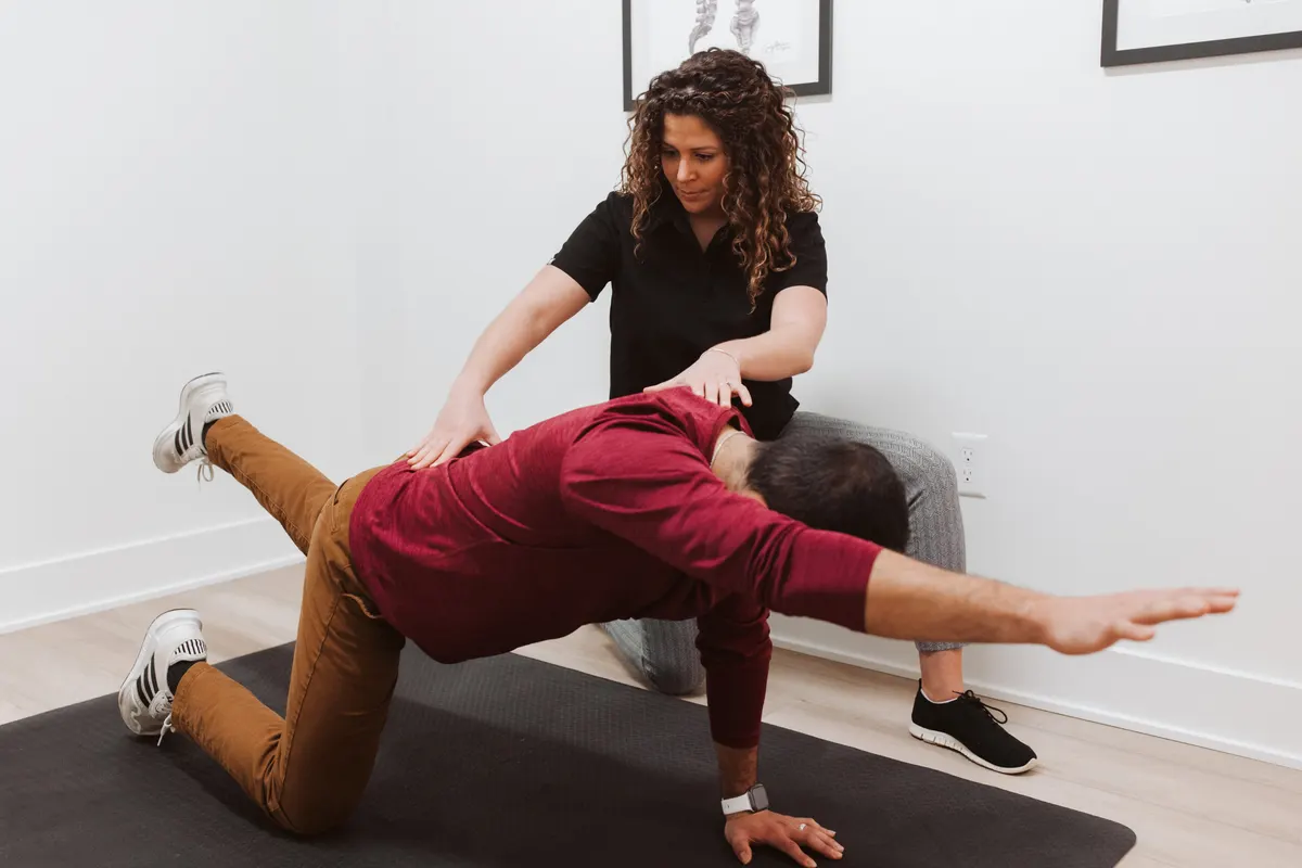 A patient at Westside Chiropractic being coached through a floor exercise
